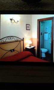 ein Schlafzimmer mit einem Bett und ein Badezimmer mit einem WC in der Unterkunft Hotel PIGNATELLI Napoli in Neapel