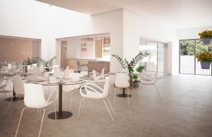 Apartment Centre of Mijas Pueblo في ميخاس: غرفة طعام مع طاولات بيضاء وكراسي بيضاء