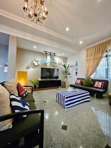a living room with a couch and a flat screen tv at Little Heaven by Sky Hive, A Beach Front Bungalow in Tanjung Bungah