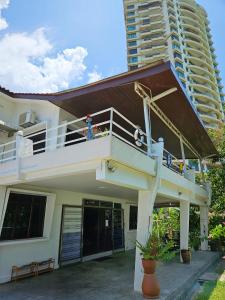 a building with a balcony with a person on it at Little Heaven by Sky Hive, A Beach Front Bungalow in Tanjung Bungah