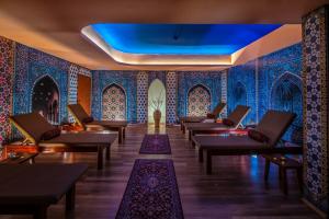 a waiting room with blue tiled walls and tables at Hotel Kapitany Wellness in Sümeg