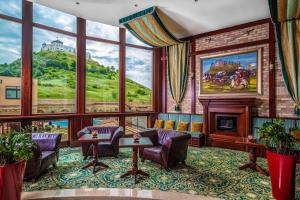 a living room with a fireplace and a large window at Hotel Kapitany Wellness in Sümeg