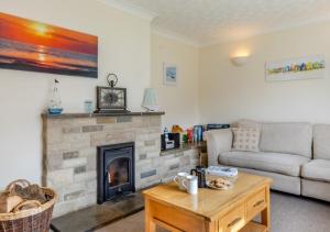 a living room with a couch and a fireplace at The Pidgeon Nest in Axmouth