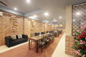 a restaurant with a table and chairs and a couch at Hotel Lemon Suites in Noida