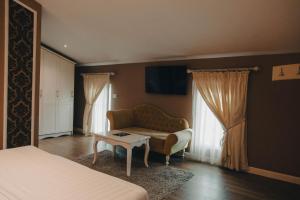 Un dormitorio con una cama, un sofá y una mesa. en Atrium Hotel, en Tirana