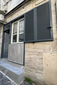 ナポリにあるSweet Houseの窓とシャッター付きの建物