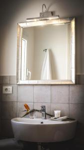 uma casa de banho com um lavatório e um espelho em MaNanna B&B em Marzamemi