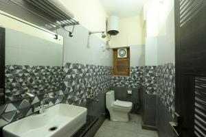 a bathroom with a sink and a toilet at Hotel Lemon Suites & Banquet - Corporate Hotel in Noida