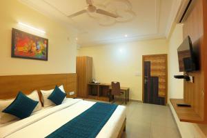 a bedroom with a large bed and a television at Hotel Lemon Suites in Noida
