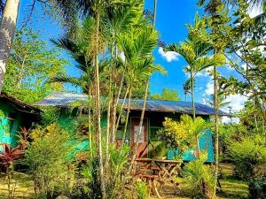 ein grünes Haus mit Palmen davor in der Unterkunft A. Zaragosa Lodging House in San Vicente