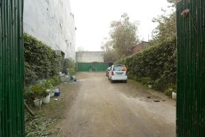 une voiture garée sur le côté d'un chemin de terre dans l'établissement Hotel Lemon Suites, à Noida