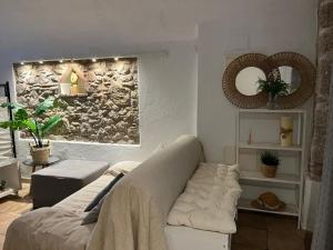 - un salon avec un canapé et un mur en pierre dans l'établissement Reconnectar Ca La Noni, à Calonge