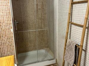 La salle de bains est pourvue d'une douche avec une porte en verre. dans l'établissement Reconnectar Ca La Noni, à Calonge