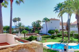 ein Resort mit einem Pool und Palmen in der Unterkunft 1176 beach front 2 pools bahia in Marbella