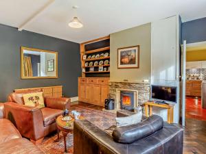 a living room with a leather couch and a fireplace at 2 Bed in Withypool 77363 in Withypool
