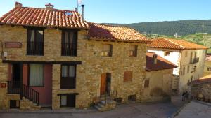 an old stone building with red tile roofs at Apartamentos Sol Valdelinares in Valdelinares