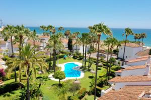 ein Luftblick auf ein Resort mit einem Pool und Palmen in der Unterkunft 1176 beach front 2 pools bahia in Marbella