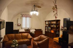sala de estar con sofá, sillas y estante para libros en Il Cortile nel Borgo, en Lanciano