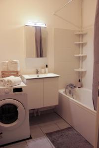 a bathroom with a washing machine and a sink at *Claire : Appartement avec *balcon + parking* in Mantes-la-Jolie