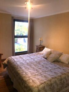 um quarto com uma cama grande e uma janela em Departamento Residencial en Capital Mendoza. em Mendoza