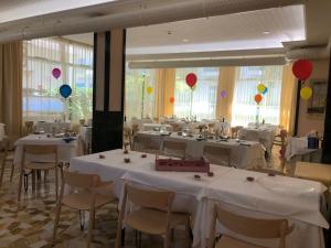 einen Bankettsaal mit weißen Tischen, Stühlen und Ballons in der Unterkunft Hotel Lazzarini in Bellaria-Igea Marina