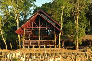 a large wooden cabin in the middle of a forest at Borneo Natural Sukau Bilit Resort in Bilit