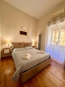 a bedroom with a bed with two towels on it at Luisa Apartments in Naples