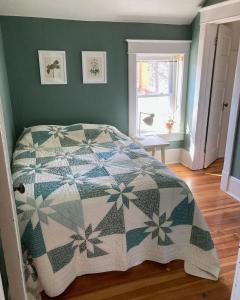 een slaapkamer met een bed met een quilt bij Garden Guesthouse in Viroqua