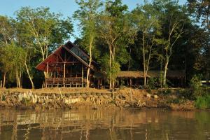 a house on the shore of a body of water at Borneo Natural Sukau Bilit Resort in Bilit