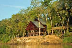 a house on the banks of a river at Borneo Natural Sukau Bilit Resort in Bilit