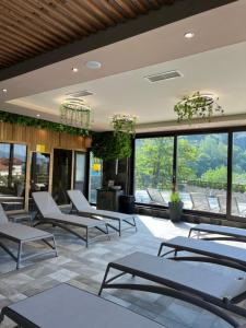 a room with chairs and tables and windows at Family Hotel Ognyanovo in Ognyanovo
