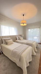 a bedroom with three beds with white sheets at Sunset Cabedelo Residence - Heated Pool in Viana do Castelo