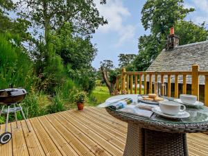 a wooden deck with a table with cups and saucers at 1 Bed in Crieff 85244 in Crieff