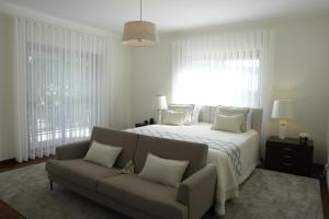 a white bedroom with a bed and a couch at Sunset Cabedelo Residence - Heated Pool in Viana do Castelo