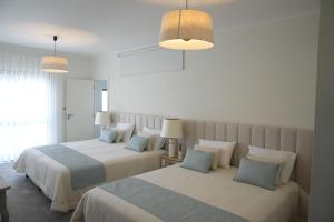 two beds in a hotel room with two lamps at Sunset Cabedelo Residence - Heated Pool in Viana do Castelo