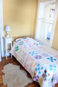 een slaapkamer met een bed, een raam en een tapijt bij Garden Guesthouse in Viroqua