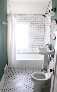 een badkamer met een toilet, een wastafel en een bad bij Garden Guesthouse in Viroqua