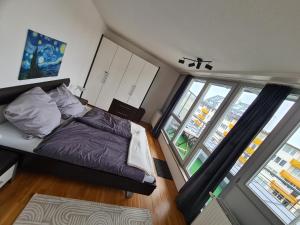 ein Schlafzimmer mit einem Bett und einem großen Fenster in der Unterkunft Ridler! Theresienwiese Oktoberfest, parking & rooftop terraces 2 room in München