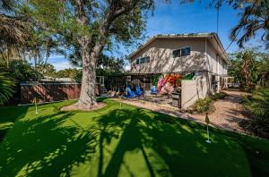 a house with a tree and a green yard at Snook Haven in Clearwater Beach