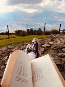a person laying on a rock with a book at En las Nubes in Medellín