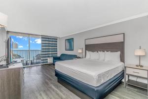 マートルビーチにあるIndigoのベッドとテレビが備わるホテルルームです。