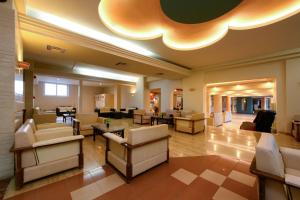 a lobby with couches and chairs in a building at Potamaki Beach Hotel in Benitses