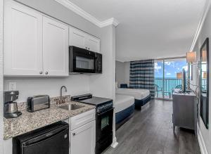 una cocina con fregadero y una cama en una habitación en Indigo, en Myrtle Beach