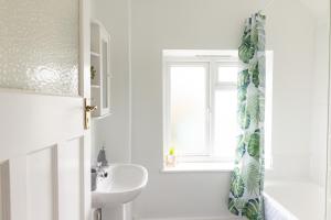 a white bathroom with a sink and a window at The Heart of Crawley in Crawley