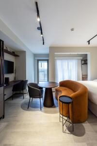 a hotel room with a bed and a table and chairs at Charlie On The Parc Ibirapuera Hotel in Sao Paulo