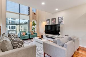 uma sala de estar com 2 sofás e uma televisão de ecrã plano em Luxe Newark Retreat with Rooftop Deck Pets Welcome! em Newark