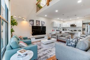 ein Wohnzimmer mit 2 blauen Sofas und einem TV in der Unterkunft Luxe Newark Retreat with Rooftop Deck Pets Welcome! in Newark