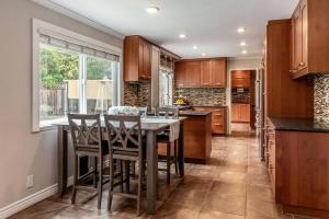 聖荷西的住宿－Silicon Valley Family Oasis 5-bedroom Luxury Home，厨房配有木制橱柜和桌椅