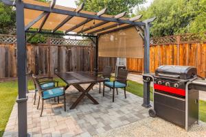 聖荷西的住宿－Silicon Valley Family Oasis 5-bedroom Luxury Home，一个带烧烤架和桌椅的庭院