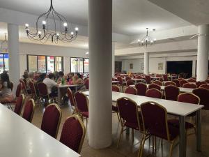 a room with tables and chairs and people sitting at tables at Grand Hotel by MH in Termas de Río Hondo